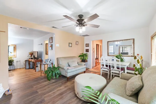a living room with furniture and a wooden floor