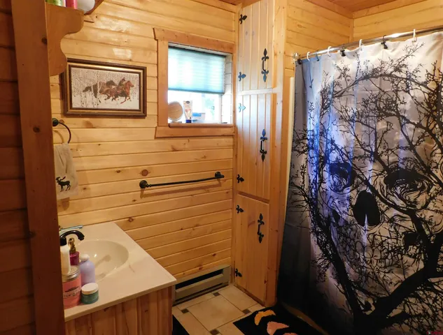 a bathroom with a glass door shower and a sink