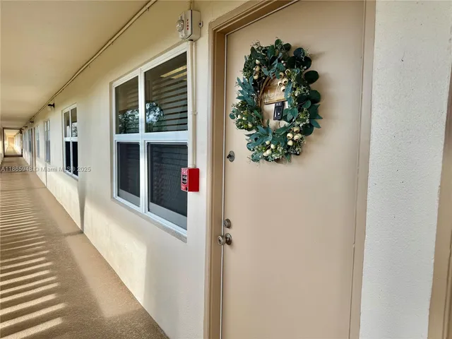 a hallway with wooden floor and a potted plant