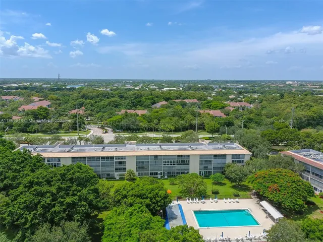 an aerial view of a swimming pool with outdoor seating