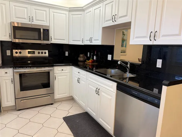 a kitchen with stainless steel appliances granite countertop a stove a sink a microwave and cabinets