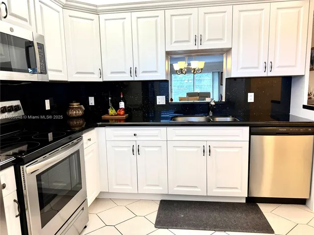 a kitchen with granite countertop a stove a microwave and cabinets