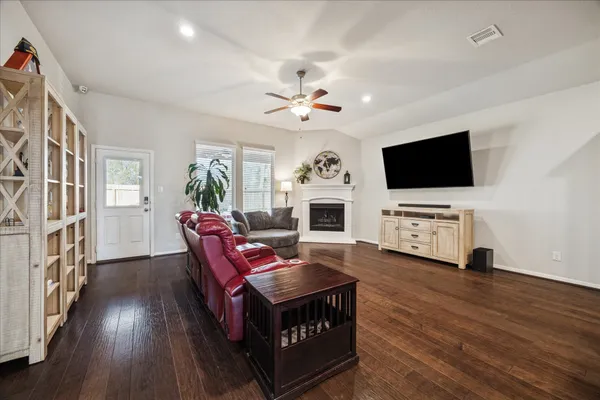 a view of a hallway with wooden floor and a bathroom