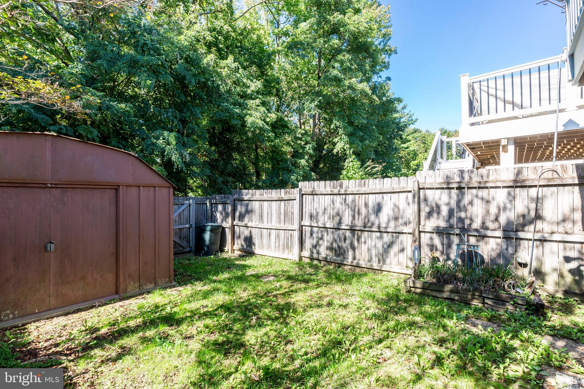 502 Brighton Place Baltimore, MD 21221 - Photo 35 of 42 a view of a backyard with a garden and wooden fence