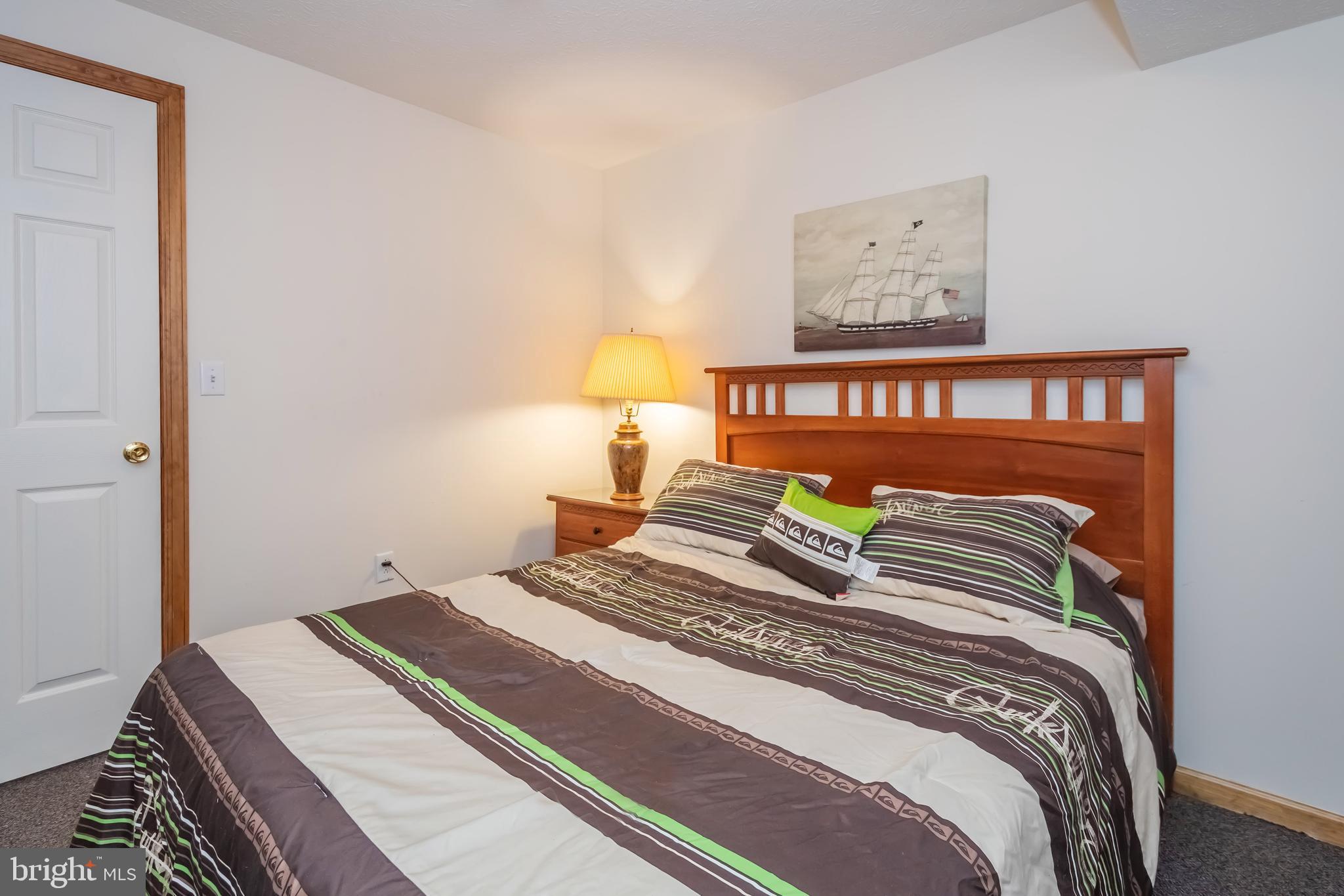 592 Marsh Hill Road McHenry, MD 21541 - Photo 33 of 51 a bedroom with a bed and a lamp on dresser