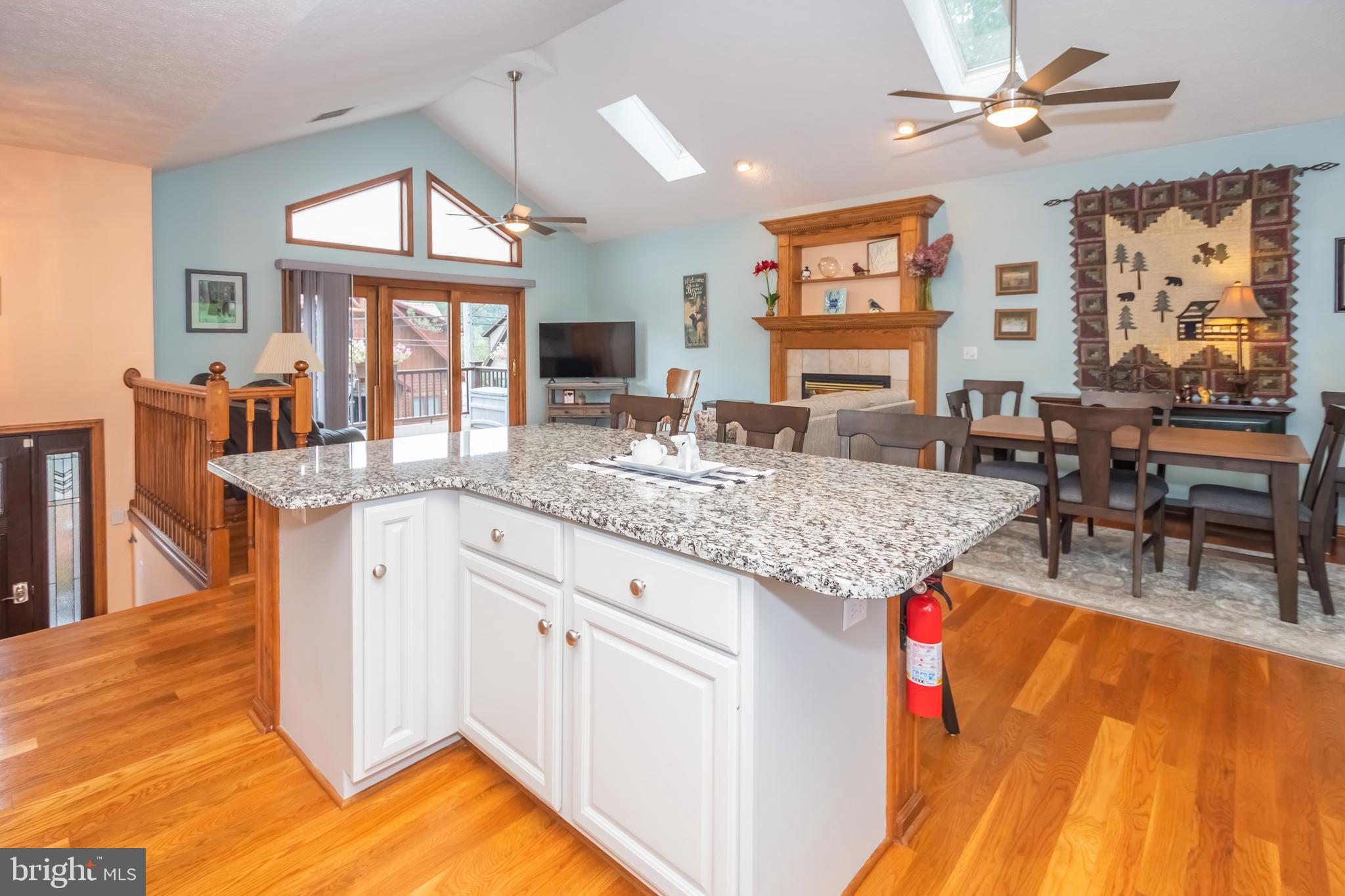 592 Marsh Hill Road McHenry, MD 21541 - Photo 8 of 51 a kitchen with granite countertop a stove a sink a dining table and chairs