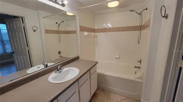 a bathroom with a sink double vanity granite tub shower and a mirror