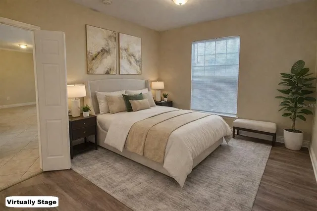 a spacious bedroom with a bed and a potted plant