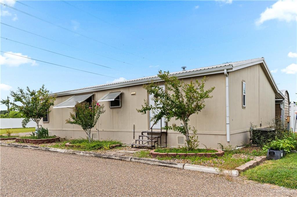 215 South Valley View Road, Unit 252 Donna, TX 78537 - Photo 15 of 19 Single-story residence featuring a neutral-toned exterior siding and a pitched metal roof