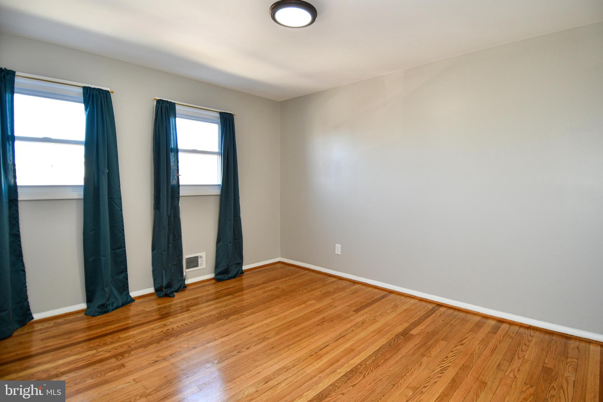 4223 Labyrinth Road Baltimore, MD 21215 - Photo 11 of 22 a view of an empty room with wooden floor and a window
