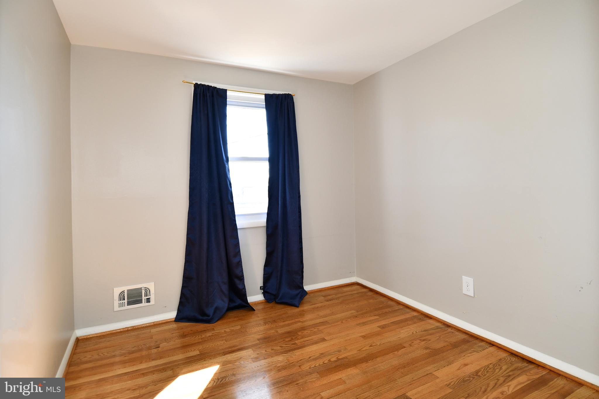 4223 Labyrinth Road Baltimore, MD 21215 - Photo 15 of 22 a view of an empty room with wooden floor