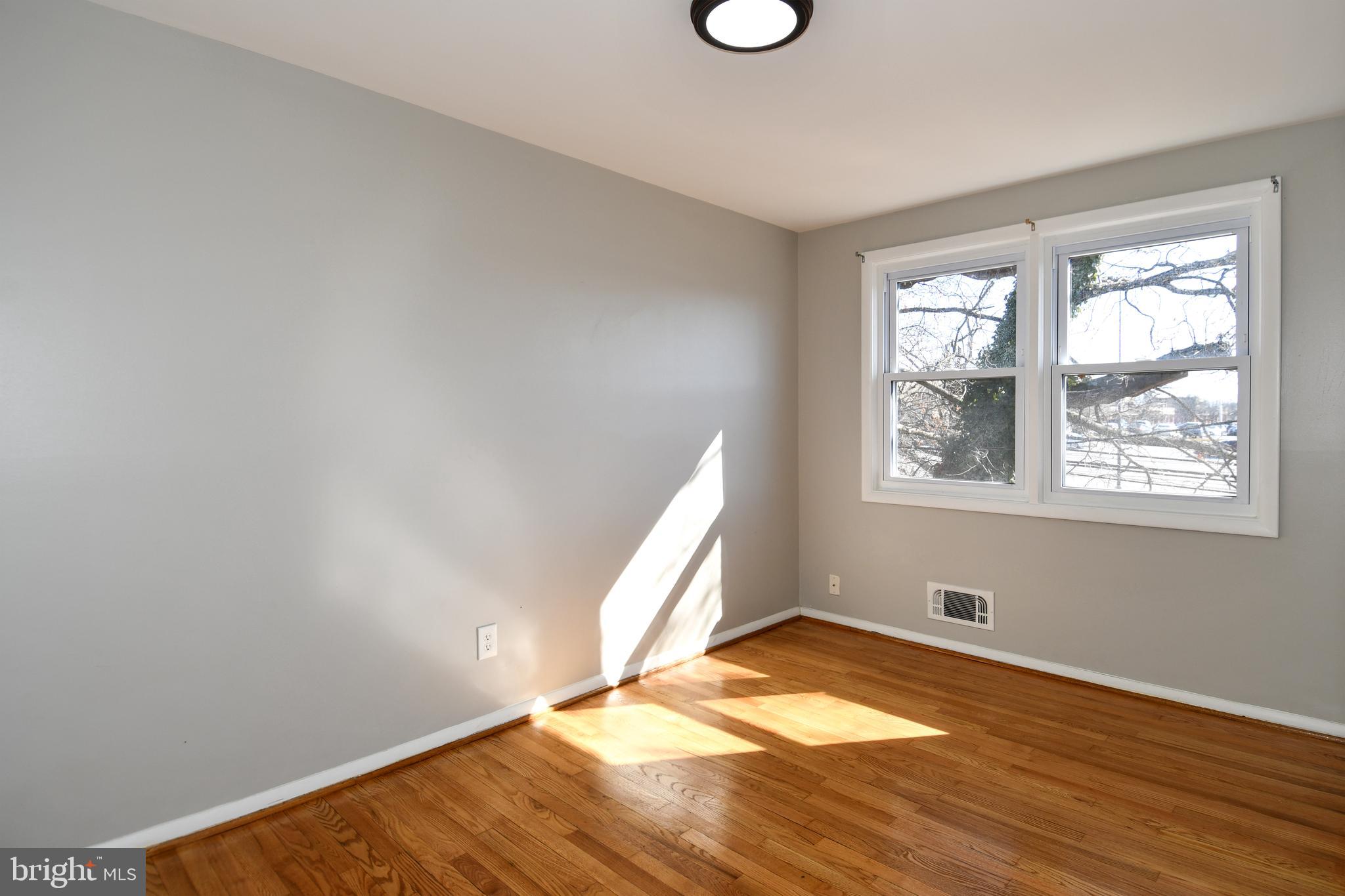 4223 Labyrinth Road Baltimore, MD 21215 - Photo 17 of 22 a view of empty room with wooden floor and fan