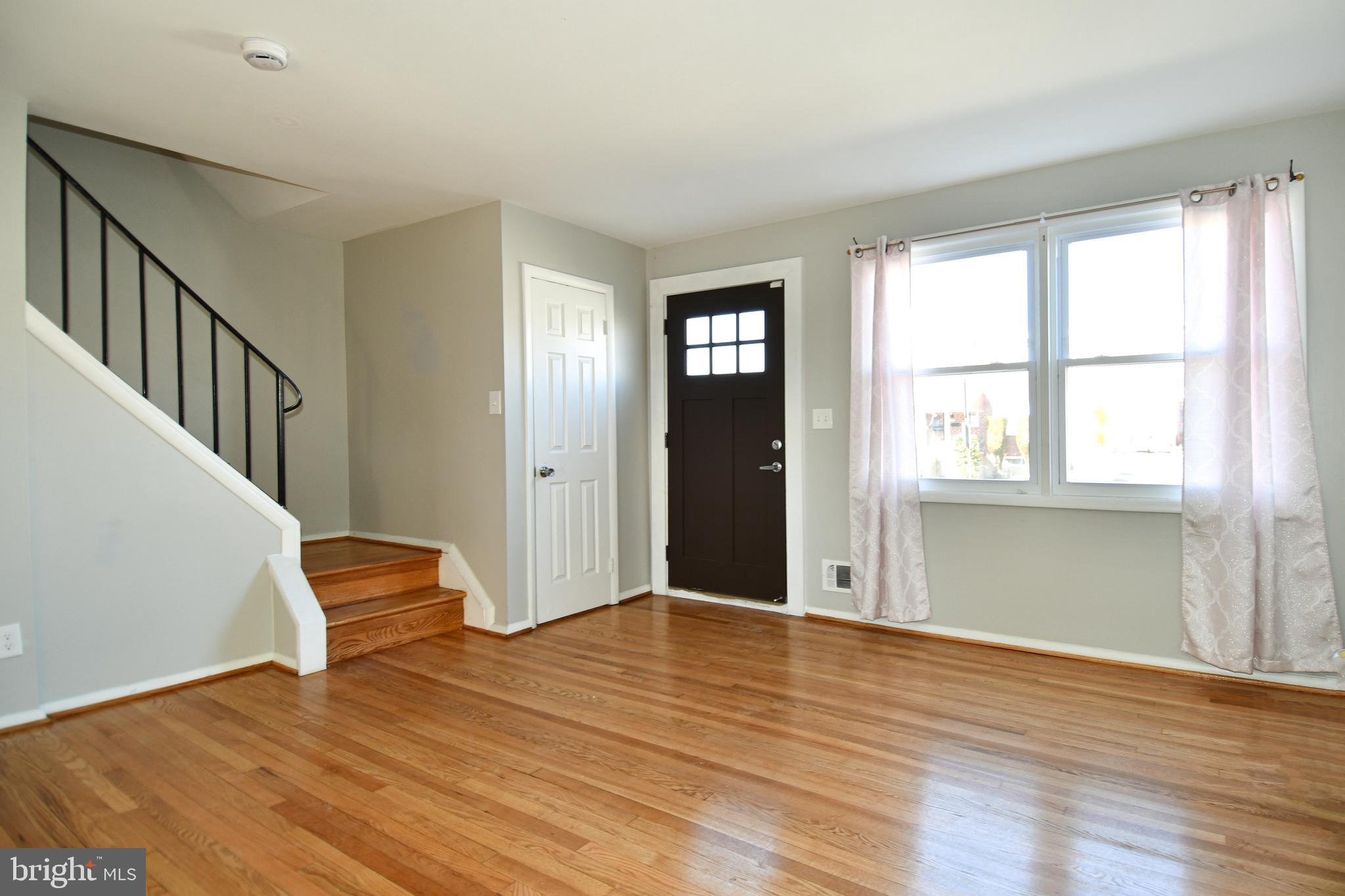 4223 Labyrinth Road Baltimore, MD 21215 - Photo 2 of 22 a view of an empty room with wooden floor and a window