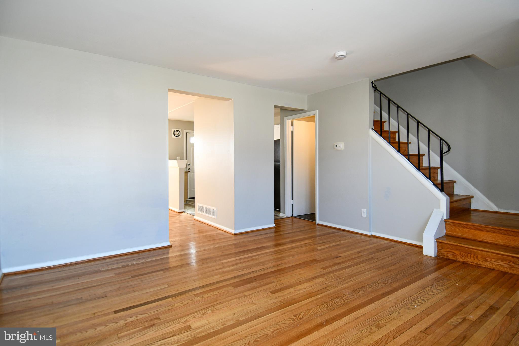 4223 Labyrinth Road Baltimore, MD 21215 - Photo 3 of 22 a view of an empty room with wooden floor and stairs