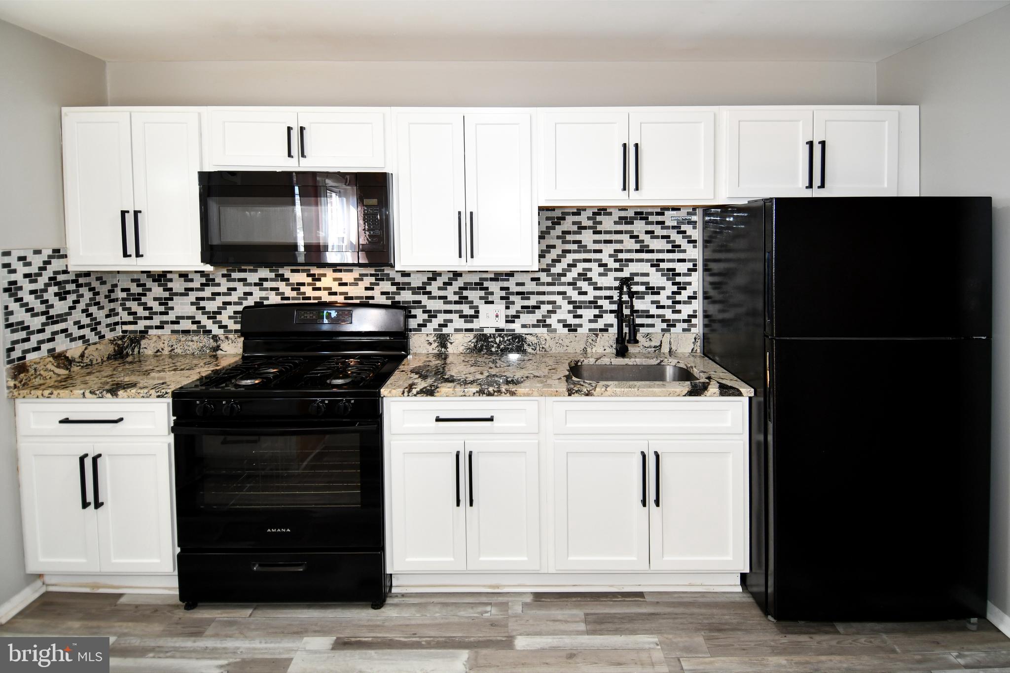 4223 Labyrinth Road Baltimore, MD 21215 - Photo 7 of 22 a kitchen with a stove and a refrigerator