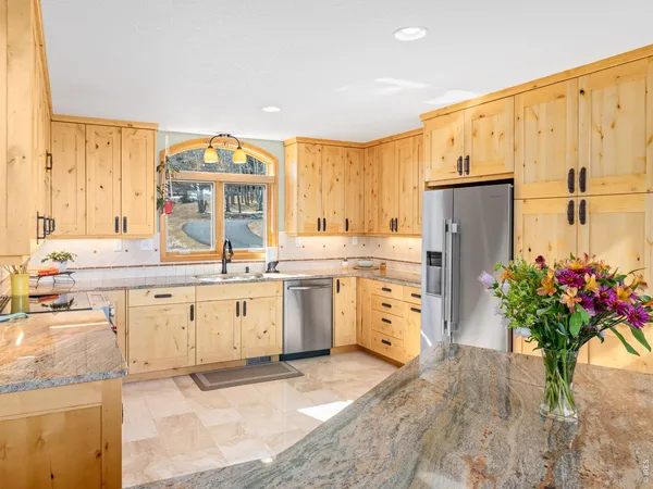 a dining hall with stainless steel appliances granite countertop a stove and a dining table with garden view