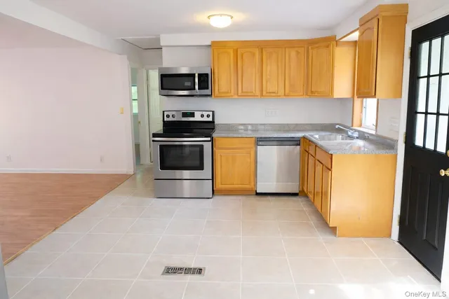 a kitchen with stainless steel appliances granite countertop a stove a sink and a microwave