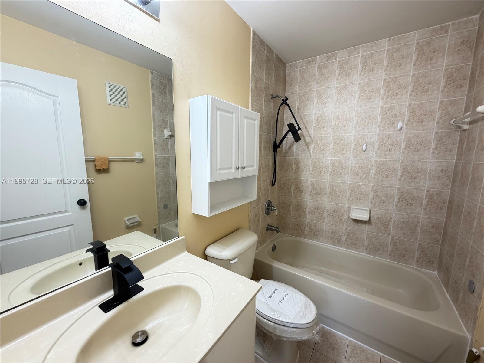 7080 Northwest 177th Street, Unit 20913 Hialeah, FL 33015 - Photo 11 of 15 a bathroom with a sink a toilet and a bathtub