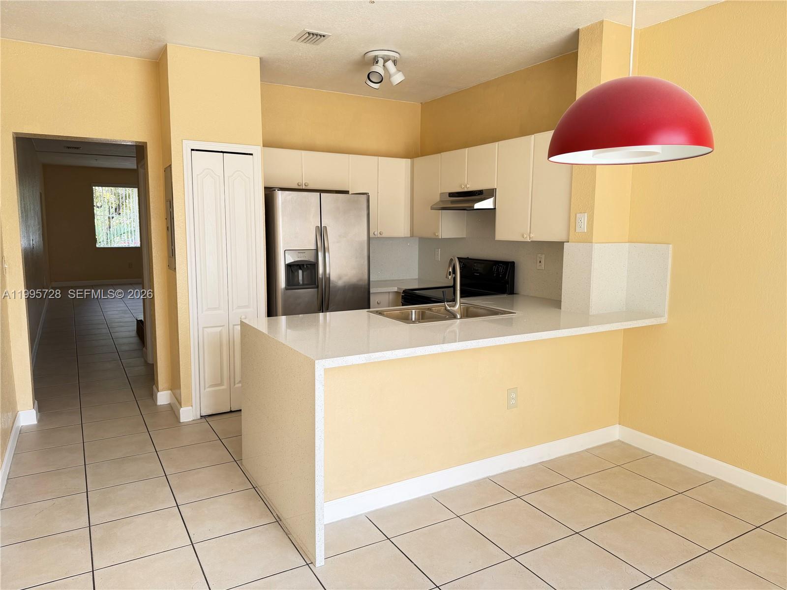 7080 Northwest 177th Street, Unit 20913 Hialeah, FL 33015 - Photo 2 of 15 a kitchen with stainless steel appliances a refrigerator and cabinets