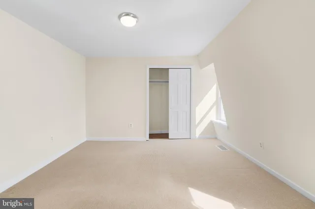 an empty room with windows and closet