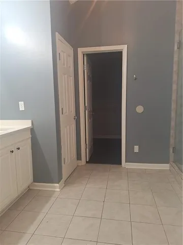 a view of an empty room with closet and mirror