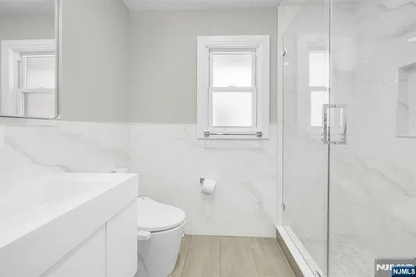 a bathroom with a sink a toilet and shower