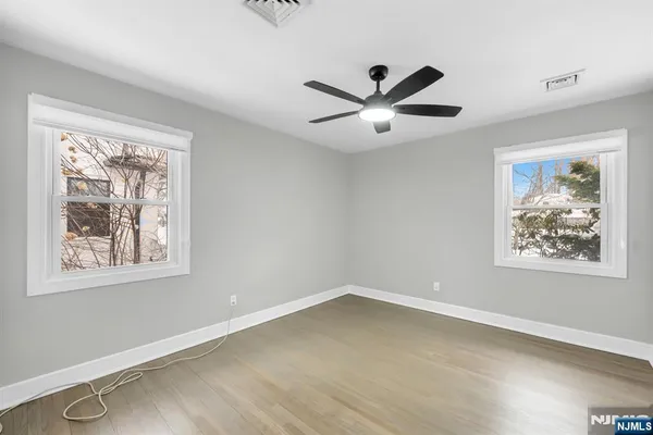 a view of an empty room with a window and a ceiling fan