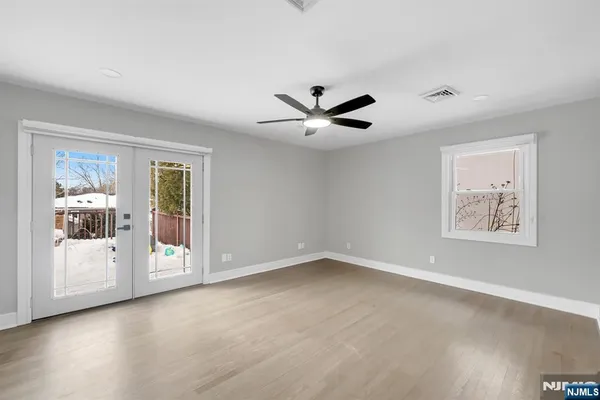 a view of an empty room with a window and a ceiling fan