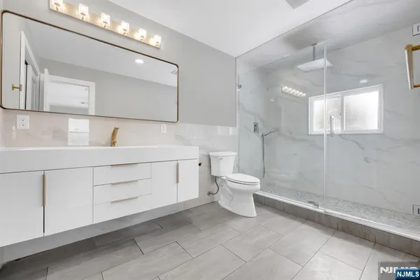 a bathroom with a toilet sink and mirror