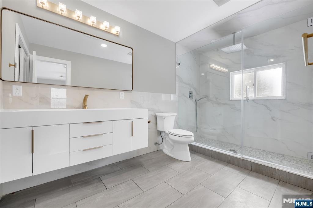 475 Cedar Lane Paramus, NJ 07652 - Photo 17 of 31 a bathroom with a toilet sink and mirror