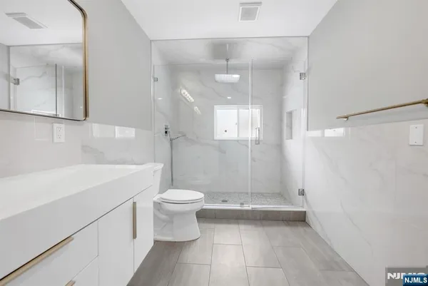 a bathroom with a sink a toilet and shower