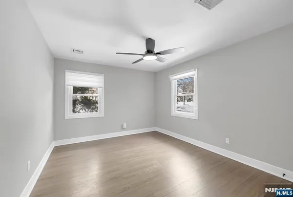 a view of a big room with wooden floor and windows
