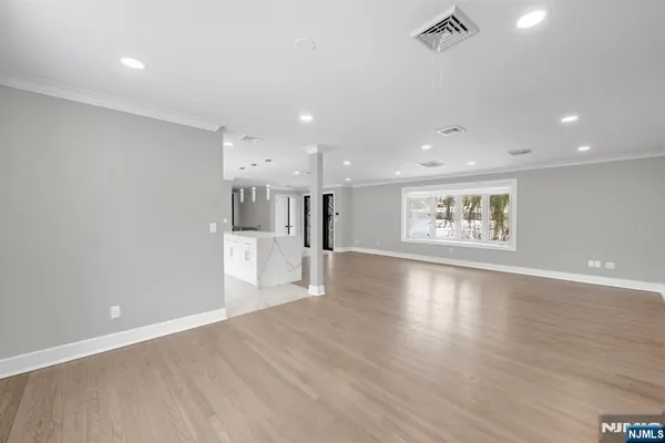 a view of a big room with wooden floor and windows