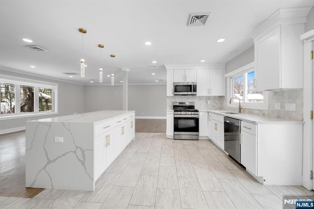 475 Cedar Lane Paramus, NJ 07652 - Photo 5 of 31 a large kitchen with a large counter top a sink stainless steel appliances and cabinets