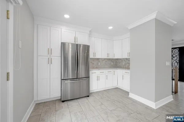 a kitchen with granite countertop a refrigerator and a stove top oven