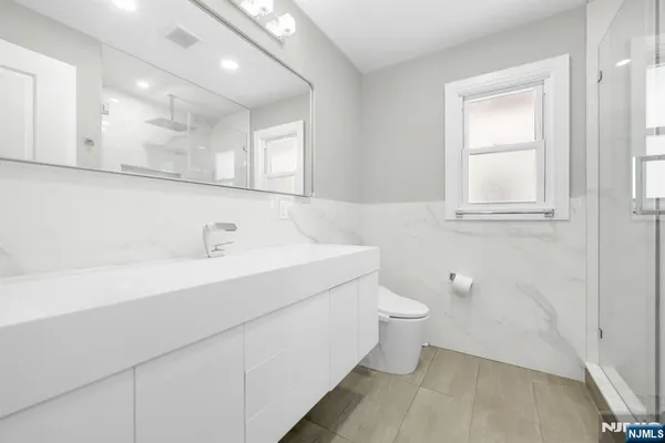 a bathroom with a sink a toilet and a mirror
