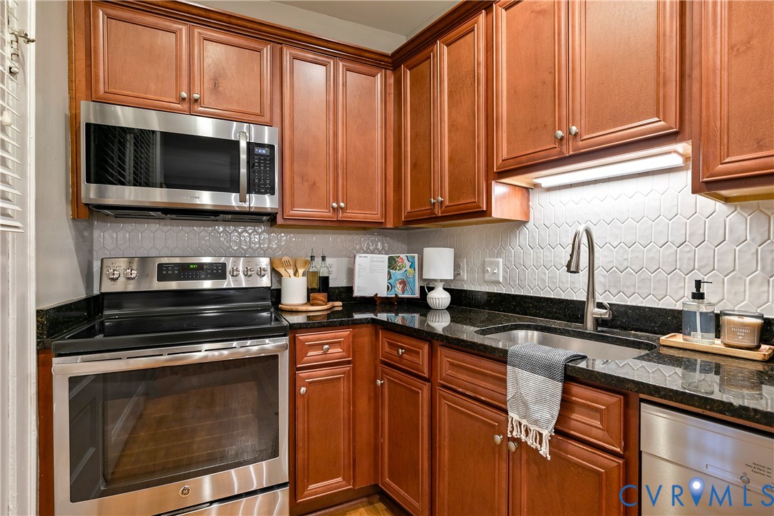 601 Roseneath Road, Unit U1 Richmond, VA 23221 - Photo 16 of 36 Kitchen featuring wood-finish cabinetry, black cou