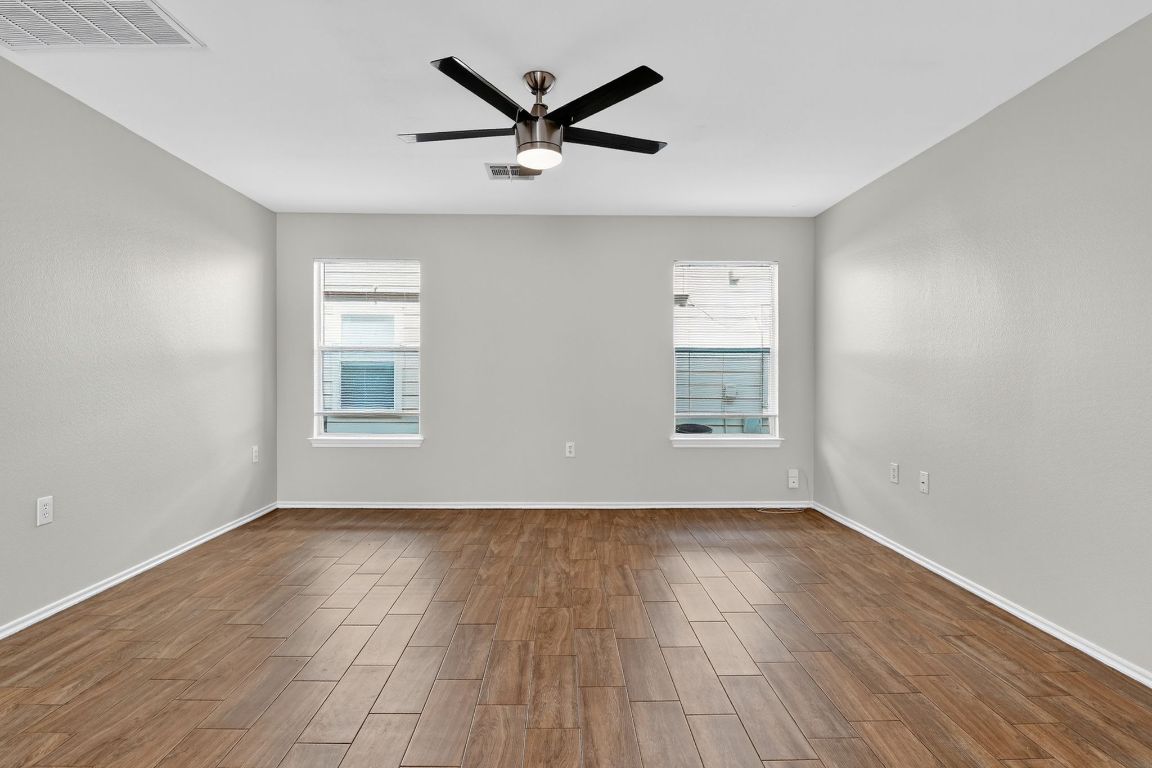 1520 Anise Drive Austin, TX 78741 - Photo 14 of 30 a view of empty room with wooden floor and ceiling fan