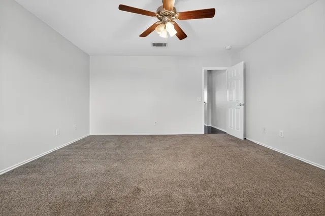 an empty room with chandelier fan