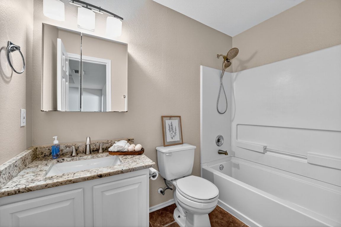 1520 Anise Drive Austin, TX 78741 - Photo 25 of 30 a bathroom with a granite countertop sink toilet and shower