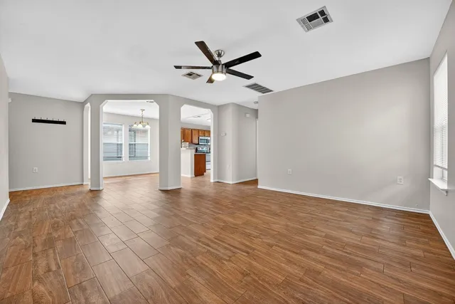 an empty room with wooden floor and windows