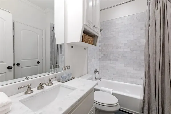 a view of a patio with a dining table and chairs under an umbrella with a large tree