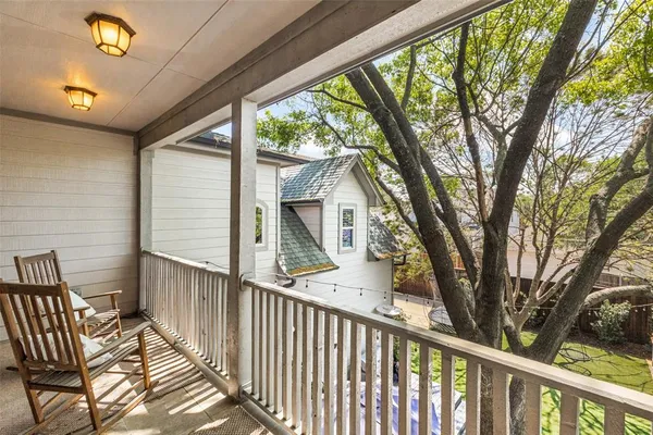 a view of a patio with table and chairs under an umbrella with a large tree