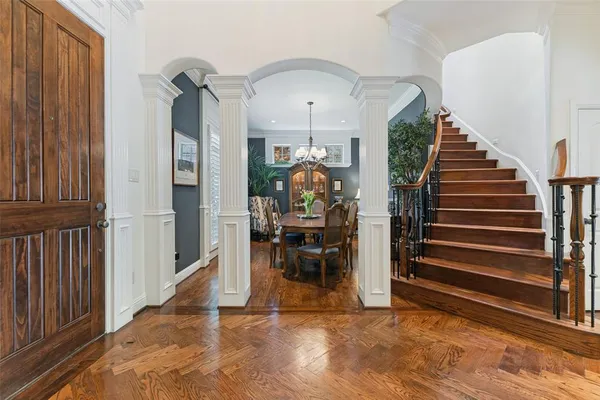 a dining room with furniture a chandelier and wooden floor