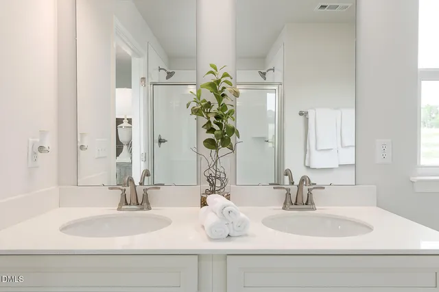 a en suite bathroom with a double vanity sink and mirror