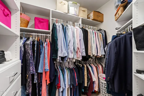 a view of walk in closet with clothes