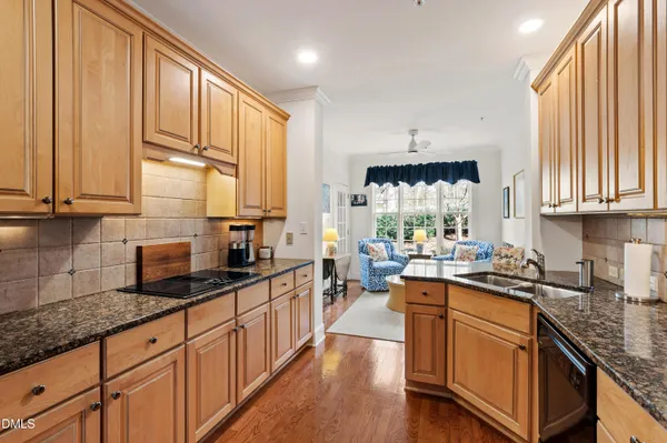 a kitchen with stainless steel appliances granite countertop a sink a stove and cabinets