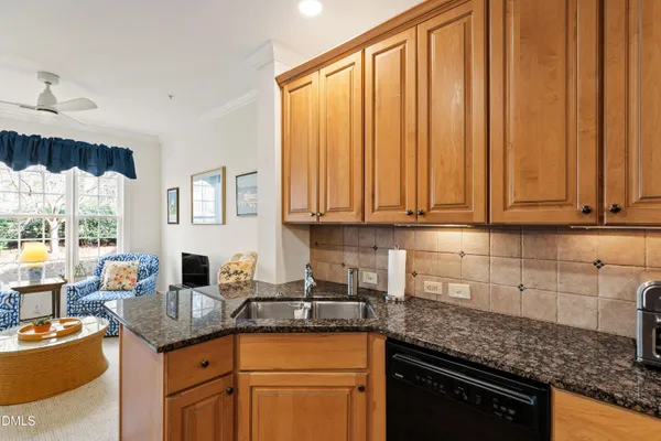 a kitchen with sink a refrigerator and wooden cabinets