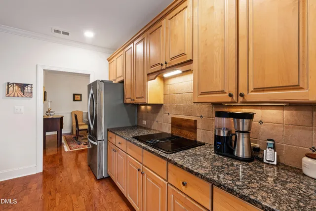 a kitchen with stainless steel appliances granite countertop a refrigerator microwave and stove