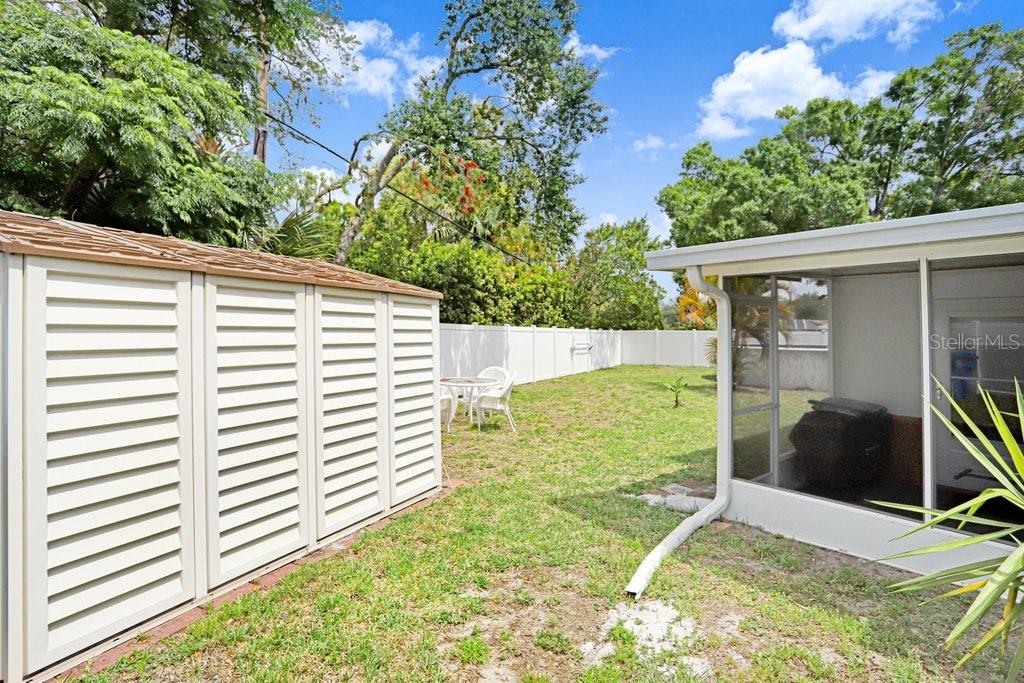 1632 Heather Place Palm Harbor, FL 34684 - Photo 45 of 53 a backyard of a house with table and chairs and a large tree